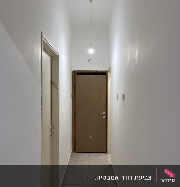 קירות מסדרון צבועים בלבן עם תאורה פשוטה